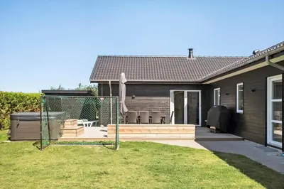 a house with a backyard with a hot tub at BL1748-Blokhus-Grossvej-5 in Blokhus
