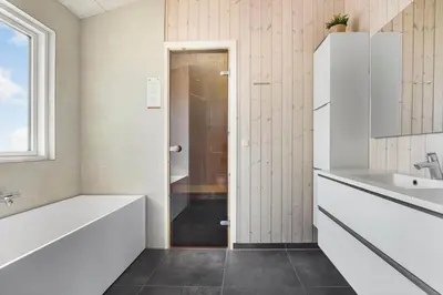 a bathroom with a white tub and a sink at BL1748-Blokhus-Grossvej-5 in Blokhus