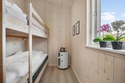 a room with two bunk beds and a window at BL1748-Blokhus-Grossvej-5 in Blokhus