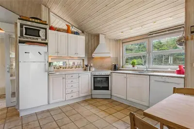 a kitchen with white appliances and a wooden ceiling at BL450-Saltum-Graabakken-8 in Saltum
