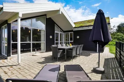 a patio with a table and an umbrella at BL1633-Saltum-Nordvestvej-18 in Saltum