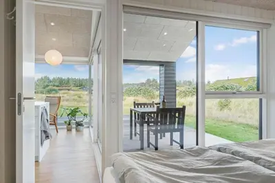 a bedroom with a table and a balcony with a view at BL1445-Saltum-Laustvej-7 in Saltum