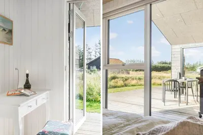 a room with sliding glass doors and a kitchen with a table at BL1445-Saltum-Laustvej-7 in Saltum