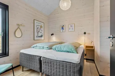 a bed in a room with wooden walls at BL1433-Blokhus-Mollevej-11 in Blokhus