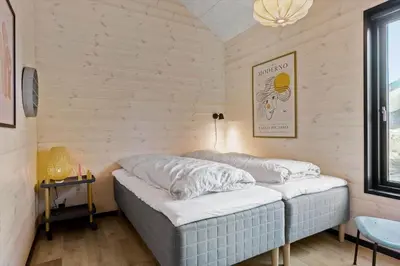 a room with a bed in a room with wooden walls at BL1433-Blokhus-Mollevej-11 in Blokhus