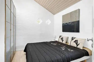 a bedroom with a bed with a black blanket at BL1588-Pandrup-Lunen-88 in Pandrup