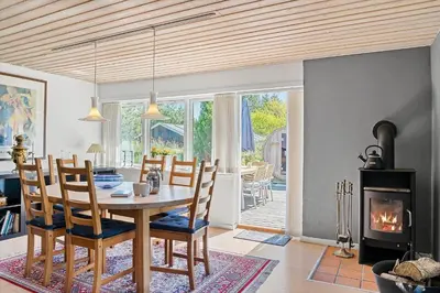 a dining room with a table and a fireplace at BL1420-Blokhus-Ronliensvej-21 in Blokhus