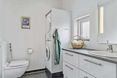 a white bathroom with a toilet and a sink at BL1492-Blokhus-Plantagevej-19-B in Blokhus