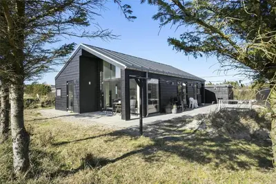 a black house with a black roof at BL1667-Blokhus-Klitvejen-24 in Blokhus