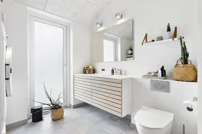 a white bathroom with a sink and a mirror at BL1667-Blokhus-Klitvejen-24 in Blokhus