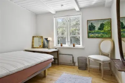 a bedroom with a bed and a desk and a window at BL1273-Blokhus-Vester-Klitvej-15 in Blokhus