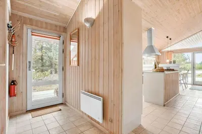 a kitchen with wood paneled walls and a white radiator at BL1426-Blokhus-Morten-Nielsensvej-86 in Blokhus