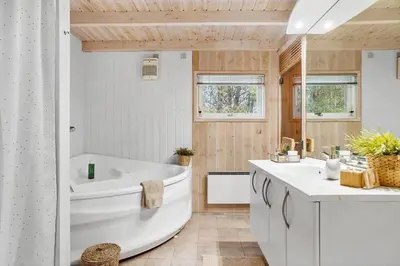 a white bathroom with a tub and a sink at BL1426-Blokhus-Morten-Nielsensvej-86 in Blokhus