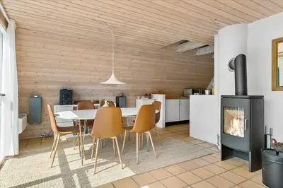 a dining room with a table and chairs and a fireplace at BL1738-Pandrup-Narhvalen-11 in Pandrup
