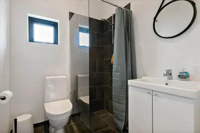 a bathroom with a toilet and a sink and a mirror at BL1513-Blokhus-Gyldenrisvej-18 in Blokhus