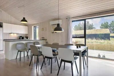 a kitchen and dining room with a table and chairs at BL1513-Blokhus-Gyldenrisvej-18 in Blokhus