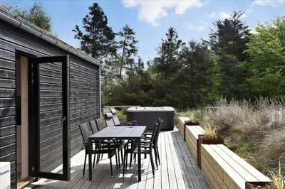 a patio with a table and chairs on a deck at BL1513-Blokhus-Gyldenrisvej-18 in Blokhus