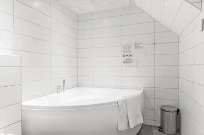 a white bathroom with a tub with a towel on it at BL1468-Blokhus-Moreavej-59-B in Blokhus