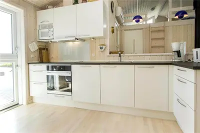 a kitchen with white cabinets and white appliances at BL289-Blokhus-Moreavej-41 in Blokhus