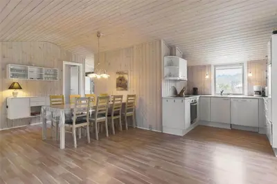 a kitchen and dining room with a table and chairs at BL489-Pandrup-Rodhusparken-24 in Pandrup