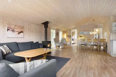 a living room with a blue couch and a table at BL489-Pandrup-Rodhusparken-24 in Pandrup