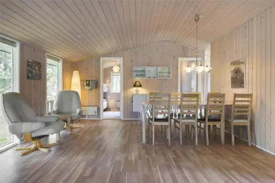 a dining room and living room with a table and chairs at BL489-Pandrup-Rodhusparken-24 in Pandrup