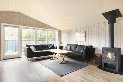 a living room with a couch and a fireplace at BL489-Pandrup-Rodhusparken-24 in Pandrup