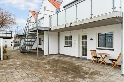 a patio with a spiral staircase on a white house at BL1708-Blokhus-Klitgaardsvej-3-D in Blokhus