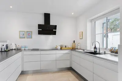 a white kitchen with a sink and a window at BL1708-Blokhus-Klitgaardsvej-3-D in Blokhus