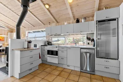 a large kitchen with white cabinets and appliances at BL1378-Blokhus-Klitvejen-65 in Blokhus