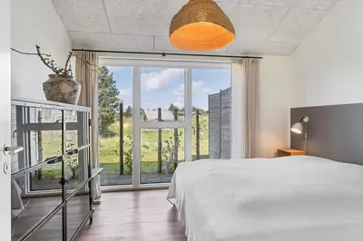 a bedroom with a bed and a large window at BL1712-Blokhus-Vestvej-6 in Blokhus