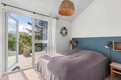 a bedroom with a bed and a large window at BL1712-Blokhus-Vestvej-6 in Blokhus