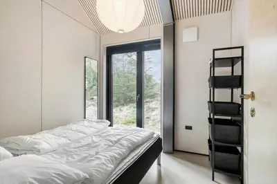 a bedroom with a bed and a glass door at BL1327-Blokhus-Braendevinsstien-5 in Blokhus