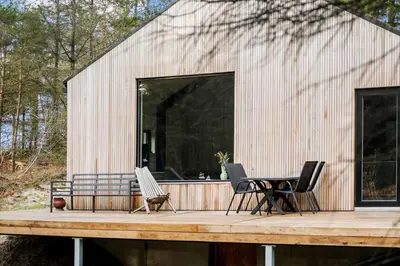a house with two chairs and a table on a deck at BL1327-Blokhus-Braendevinsstien-5 in Blokhus