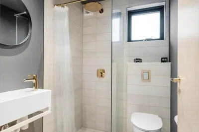 a bathroom with a shower with a toilet and a sink at BL1327-Blokhus-Braendevinsstien-5 in Blokhus