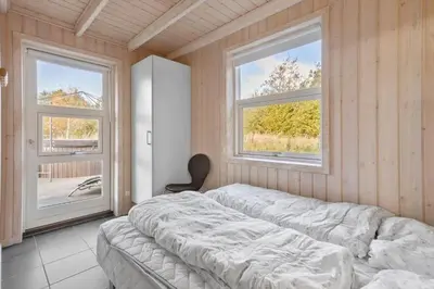 a bedroom with a bed and two windows at BL497-Saltum-Tolhoj-4 in Saltum