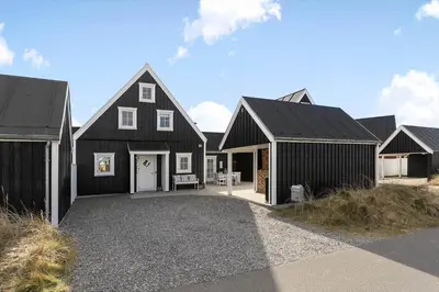 a black house with black roofs and a driveway at BL1443-Blokhus-Ferren-Syd-46 in Blokhus