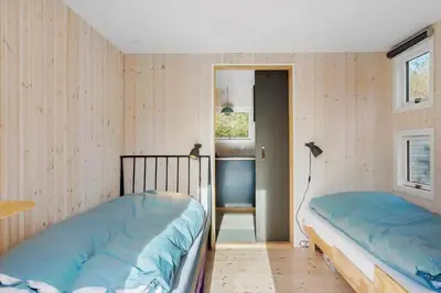two beds in a room with wooden walls at BL1589-Saltum-Bondagervej-52 in Saltum