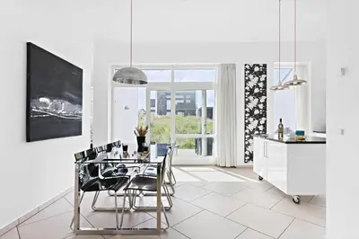 a dining room with a table and chairs and a kitchen at BL1480-Blokhus-Ferren-51 in Blokhus