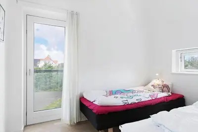 a room with a window and a bed and a door at BL1480-Blokhus-Ferren-51 in Blokhus