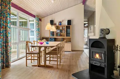 a dining room with a table and a wood stove at BL1786-Saltum-Ornebjergvej-22 in Saltum