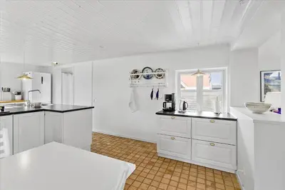 a white kitchen with white cabinets and a sink at BL395-Blokhus-Maren-Hjortelsvej-4 in Blokhus