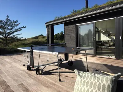 a ping pong table sitting on top of a deck at BL1740-Blokhus-Axel-P-Jensenvej-19 in Blokhus