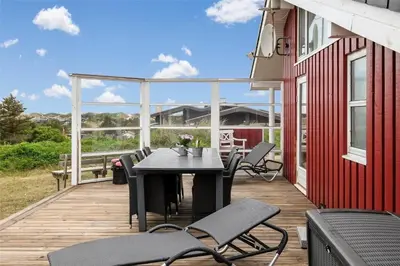 a patio with a table and chairs on a deck at BL330-Blokhus-Lyngvej-2 in Blokhus