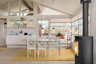 a kitchen with a table and chairs and a fireplace at BL330-Blokhus-Lyngvej-2 in Blokhus