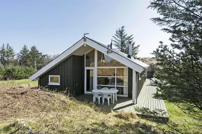 a small house with a table on a deck at BL401-Blokhus-Lyngvej-12 in Blokhus