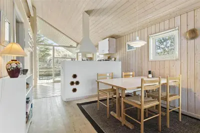 a kitchen and dining room with a table and chairs at BL401-Blokhus-Lyngvej-12 in Blokhus