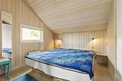 a bedroom with a bed in a wooden room at BL401-Blokhus-Lyngvej-12 in Blokhus