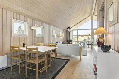 a dining room and living room with a table and chairs at BL401-Blokhus-Lyngvej-12 in Blokhus