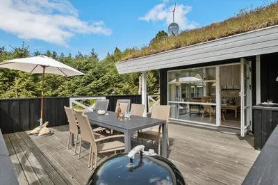 a deck with a table and chairs and an umbrella at BL279-Pandrup-Rodhusparken-71 in Pandrup